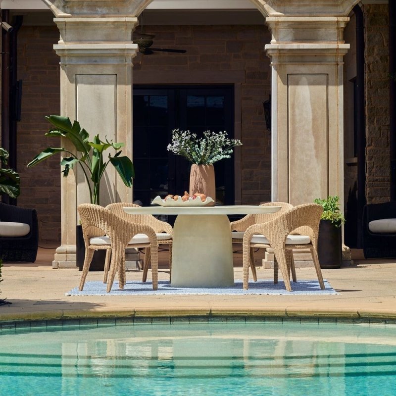 Modern outdoor dining furniture set on a patio with neutral chairs and a clean, designer look.