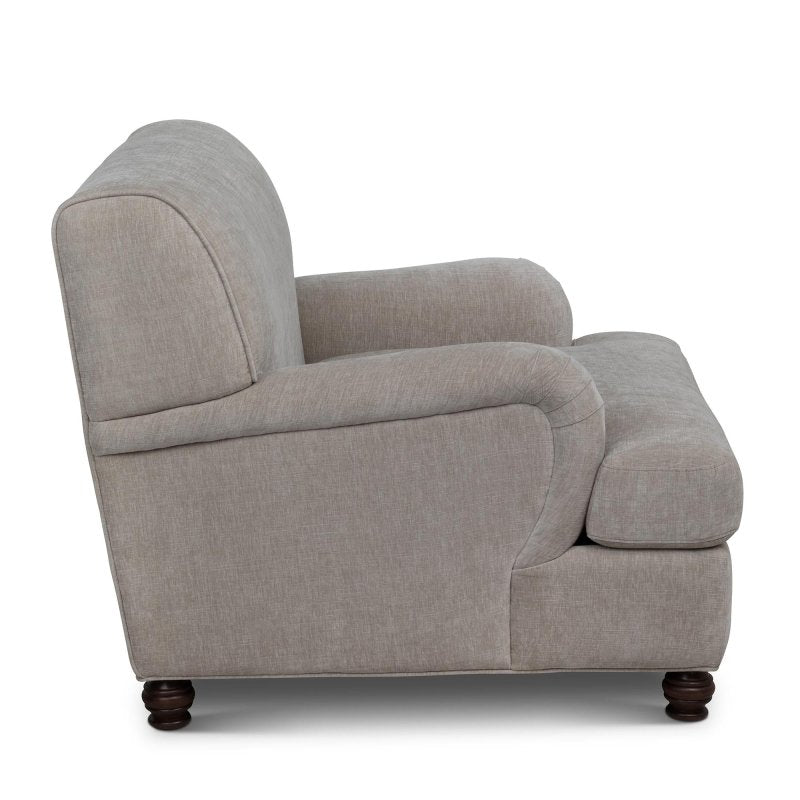Side profile of the Kenwood putty gray accent chair showing its rounded arm, cushioned seat and turned feet
