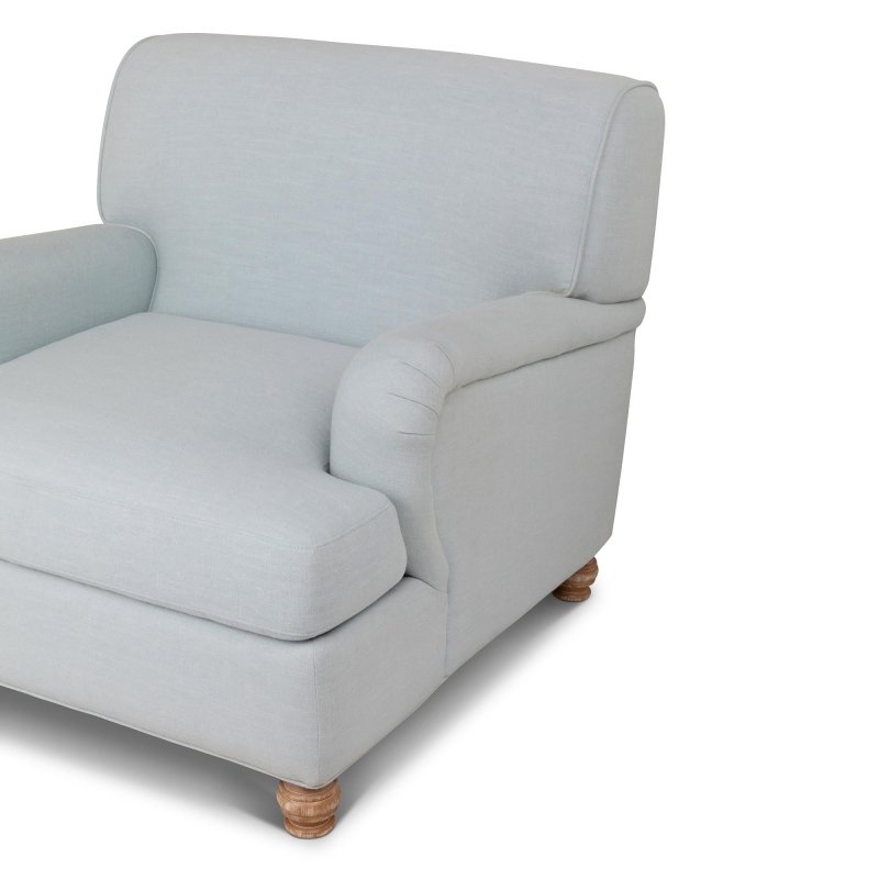 Close-up of the Kenwood Serene Sky blue chair upholstery, loose seat cushion, rounded arm and turned wood foot