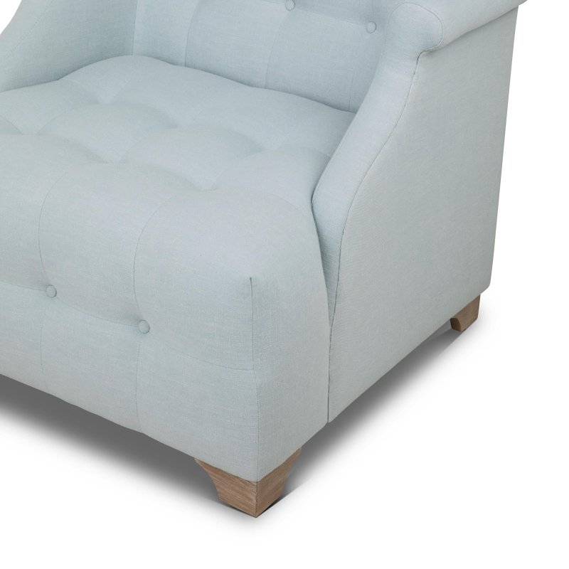 Close-up of the Scroll Arm Serene Sky blue chair showing button tufting, the rolled arm and a wood block foot