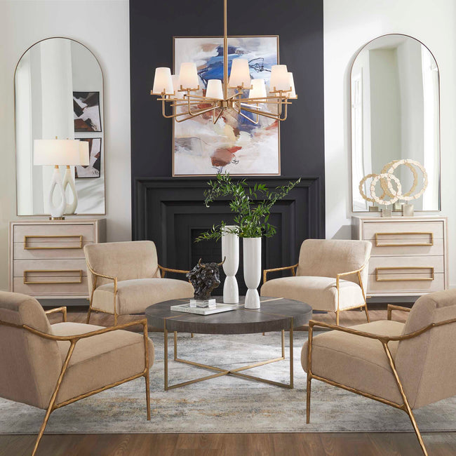 Curated modern home decor with gold chandelier, round coffee table, neutral accent chairs, and arched mirrors
