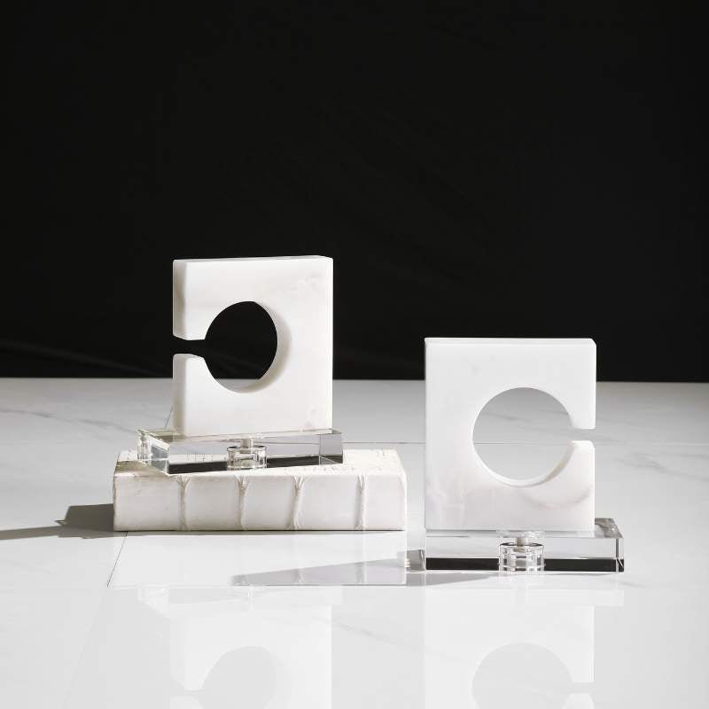 Collection of modern bookends including decorative book holders, sculptural bookends, and geometric designs in metal, marble, and stone