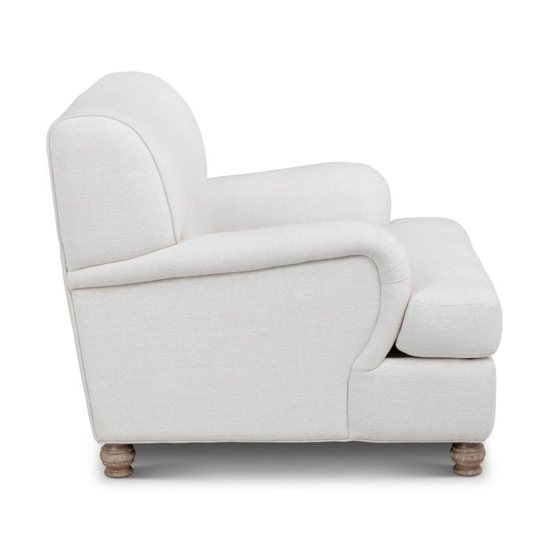 Side profile of the Kenwood ivory accent chair showing its rounded arm, cushioned seat and turned feet