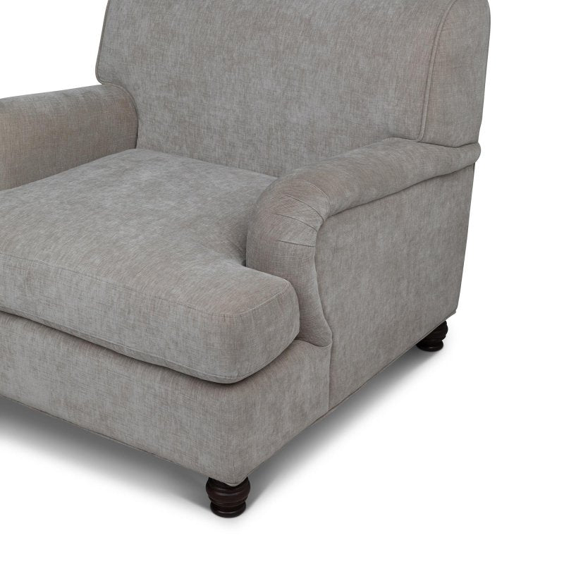 Close-up of the Kenwood putty gray chair upholstery, loose seat cushion, rounded arm and turned wood foot