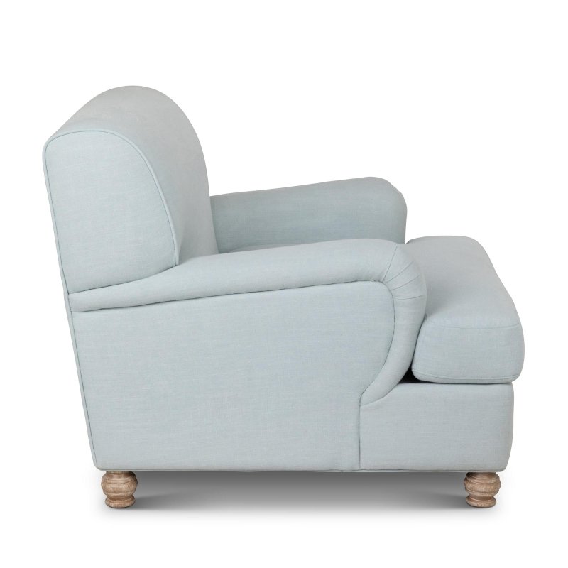 Side profile of the Kenwood Serene Sky blue accent chair showing its rounded arm, cushioned seat and turned feet