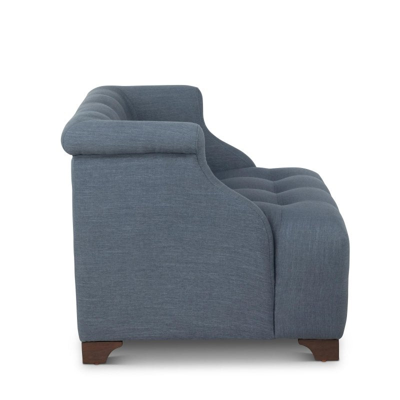 Side profile of the Scroll Arm heathered navy blue chair showing its rolled arm, deep tufted seat and wood feet