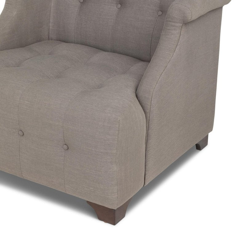 Close-up of the Scroll Arm mocha brown chair showing button tufting, the rolled arm and a wood block foot