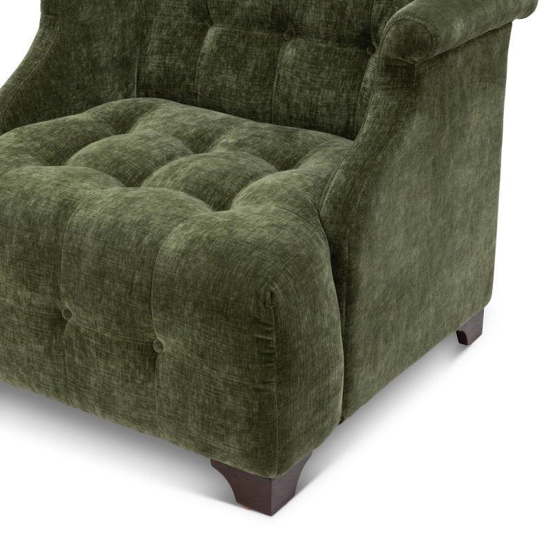 Close-up of the Scroll Arm moss green chair showing button tufting, the rolled arm and a wood block foot