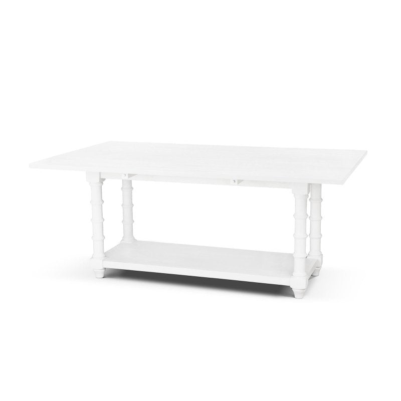 Three-quarter view of the Bimini whitewash drop-leaf dining table with both leaves raised and faux bamboo legs
