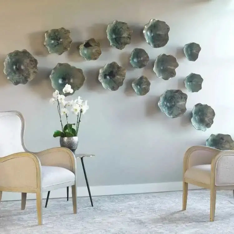 Decorative wall art with green ceramic pieces in a room with chairs and a table.